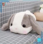 Peluche lapin gris couché