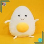 Peluche géante souriante en forme de crane d’œuf